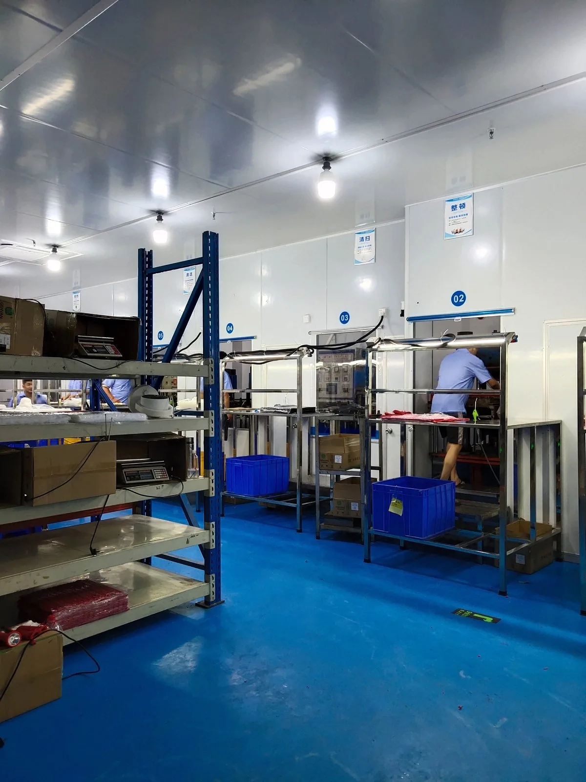 Silicone production workstations with blue flooring and parts trays