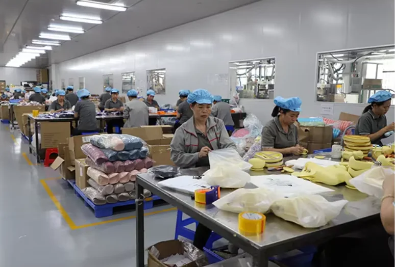 Employees packing products at factory worktables