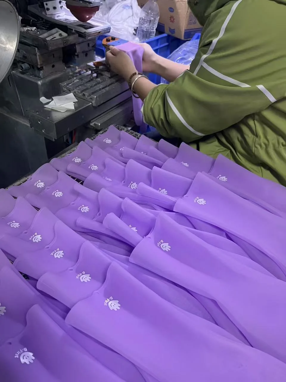 Purple silicone components being handled at a production workstation